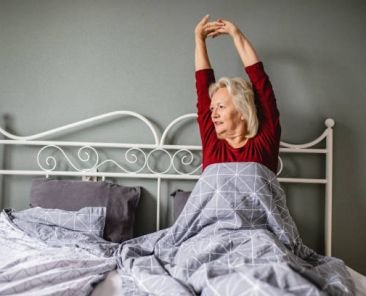 Senior woman wake up and she is stretching in bed